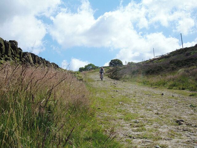 Lark Hill Road, Delph This is the section of Lark Hill Road that runs westwards off Harrop Edge. The track is very steep with a surface of loose rocks - quite a challenge on a bicycle. However, the surface improves slightly near to its junction with the A62, Huddersfield Road at Larkwood.