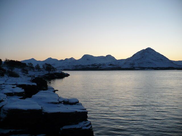 Winter sunrise over Upper Loch Torridon The sun is about to appear over the snow covered hills to the south of Upper Loch Torridon. The view from the coast near Wester Alligin.