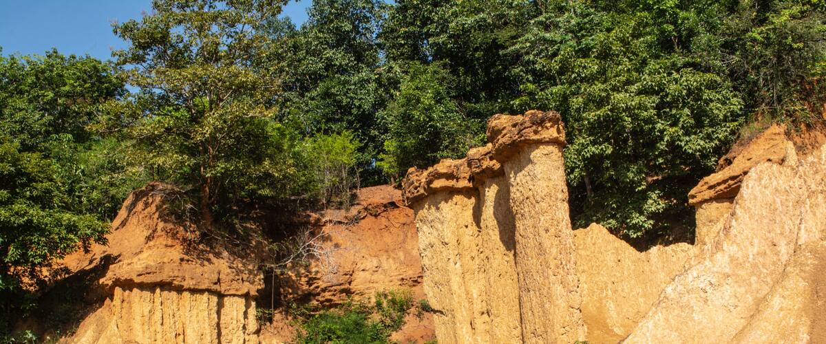 A rocky landscape with prominent sandstone formations and a dirt path.