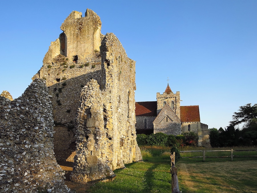 An ancient stone castle with a church in the background.