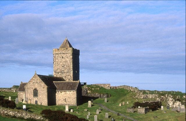 A church with a prominent tower and a graveyard in the foreground.