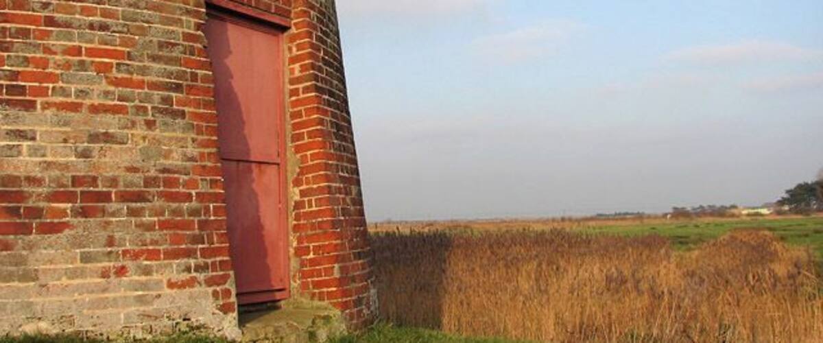 View across marsh pasture Past the entrance to West Somerton drainage mill. The buildings seen in the background (in adjacent grid square) belong to Holmes Farm. West Somerton drainage mill is located beside West Somerton Boat Dyke. The public footpath from the staithe to Martham Broad leads past here. During the 1800s, 240 drainage mills could be found in the Broads, of which 74 remain today (most are disused and derelict, a very few were converted into living accommodation). In the 13th century most of the marsh pastures in the Broads could only be grazed during the summer months, when the area was not flooded. It was during this time that sea levels were rising and flooding became more frequent. As a consequence, dykes were dug and embankments built in order to protect the grazing marshes. When this was no longer sufficient, wind-powered drainage mills were built, which pumped water from the marshes into dykes and from there into the rivers. Grazing in the marshes became more extensive from the mid-18th century onwards - the drained marshes contain lots of nutrients and the grazing is very lush. By the 19th century many of the wind-powered mills were supplemented by steam-powered pumps and during the first half of the 20th century diesel-powered pumps started to replace wind-powered drainage. Diesel pumps are much more efficient than wind drainage pumps and as it got drier, the surrounding peaty soil shrank, resulting in areas that are lower than the water level in the river and lower even than sea level. Today the marshes are drained by pumps which are electricity-powered.