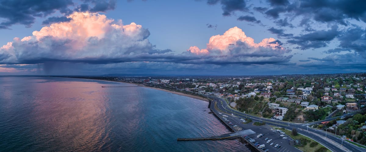 Frankston coastline with stormy clouds and rain - wide aerial panoramic landscape
