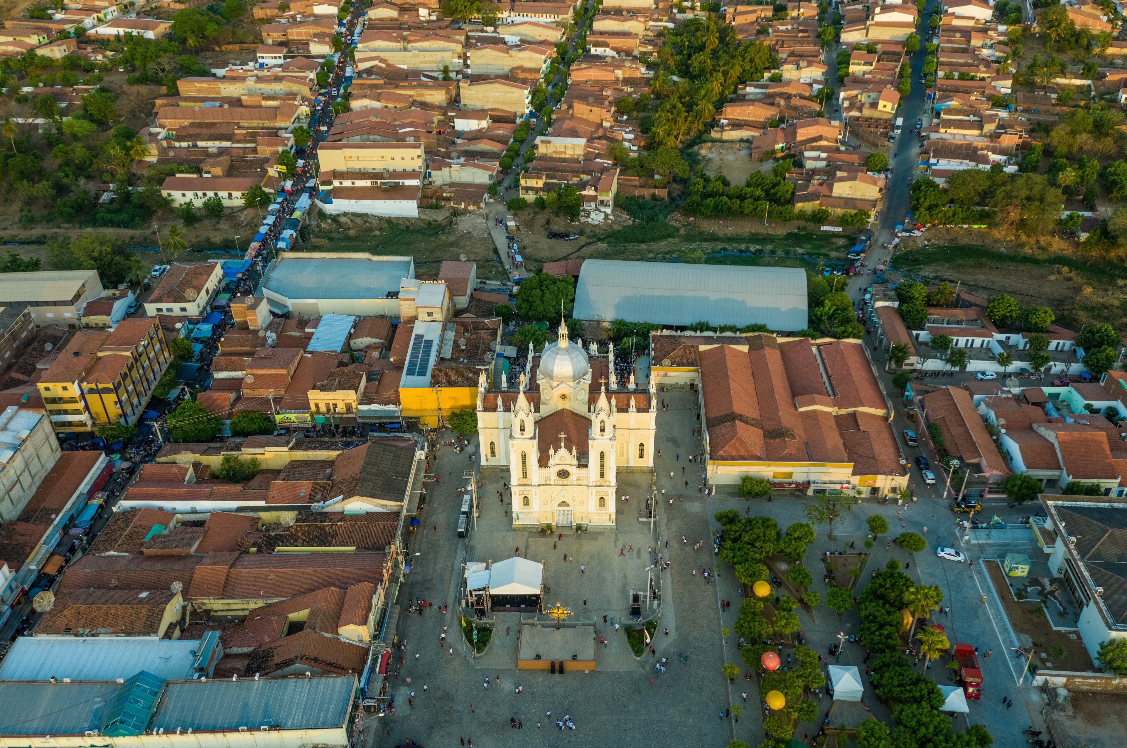 An aerial view of a city with a prominent cathedral, narrow streets, and surrounding residential buildings.
