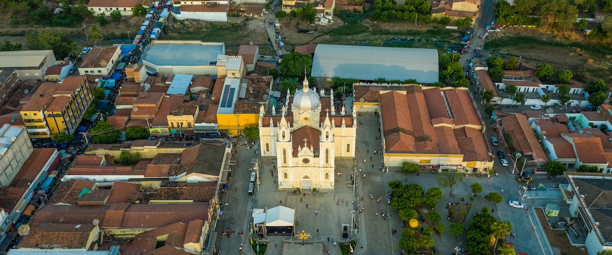An aerial view of a city with a prominent cathedral, narrow streets, and surrounding residential buildings.
