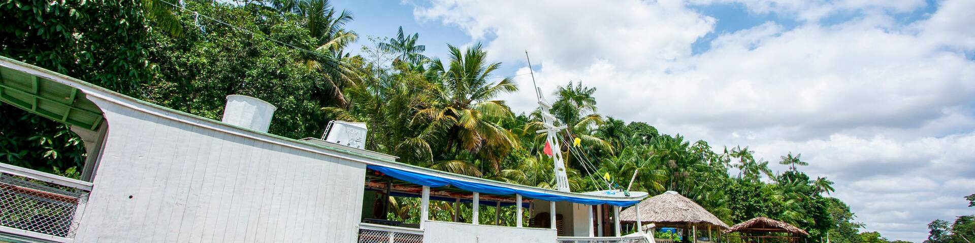 Embarcação de madeira ancorada em trapiche em um rio da floresta amazônica. Barco na margem de floresta sem pessoas