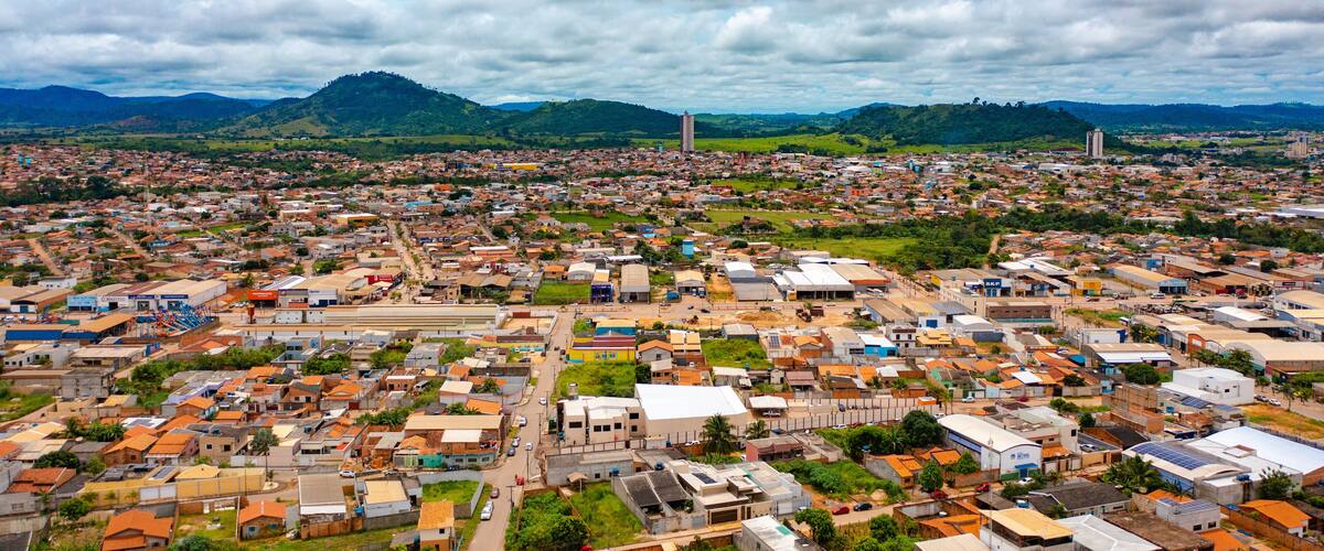 A densely populated city with a mix of residential and commercial buildings, surrounded by green hills and mountains.