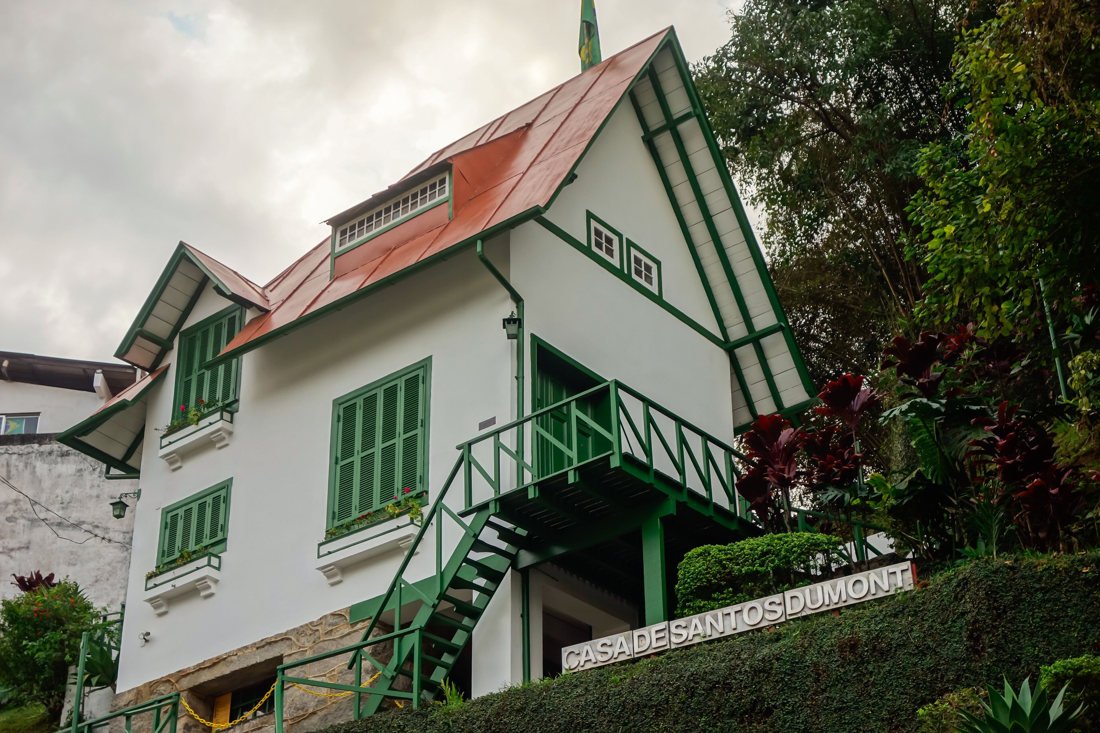 A white building with green trim and a red roof, labeled "CASA DE SANTO DOMINGO".