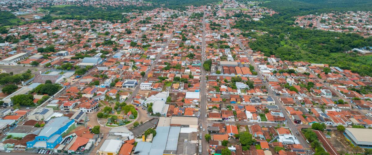 An aerial view of a densely populated urban area with red-roofed buildings and green spaces.
