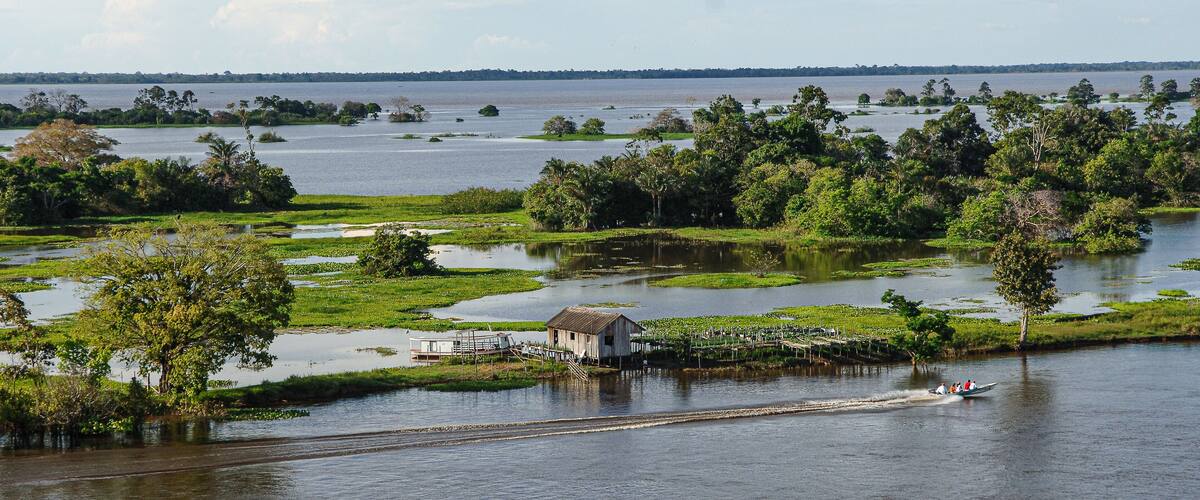 A river with a small wooden house and a boat.