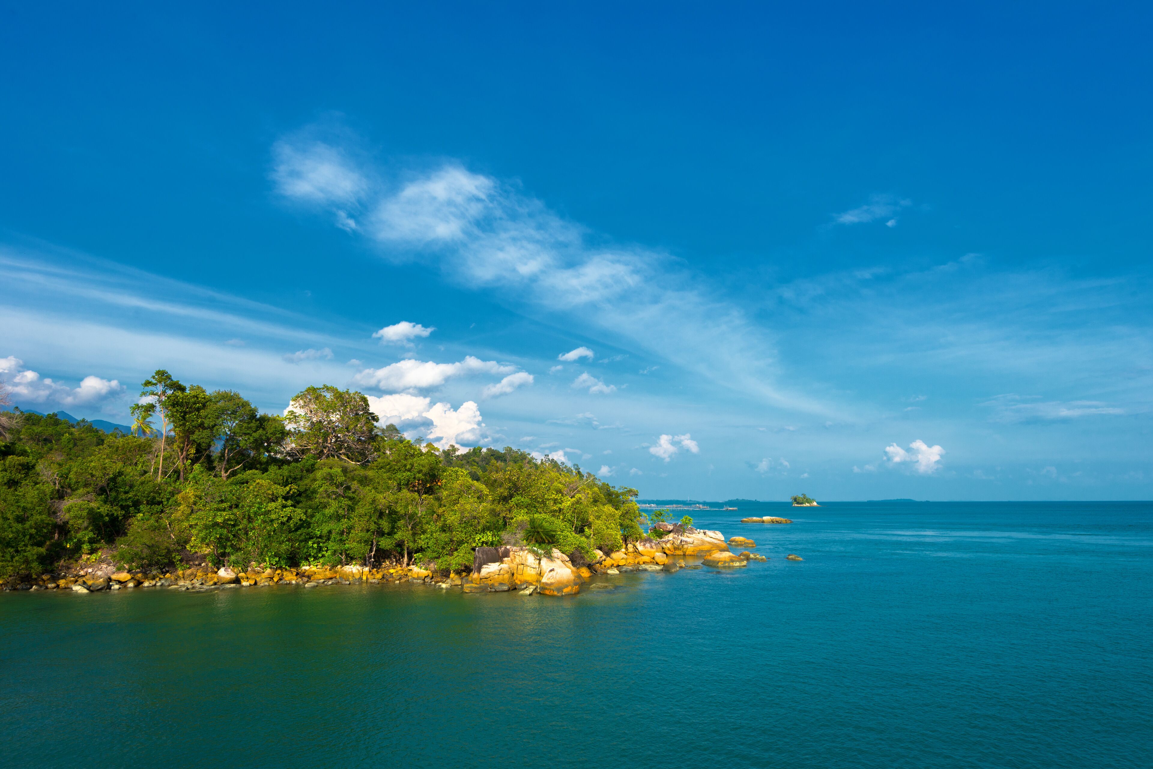 A tropical island with lush green vegetation and clear blue waters.