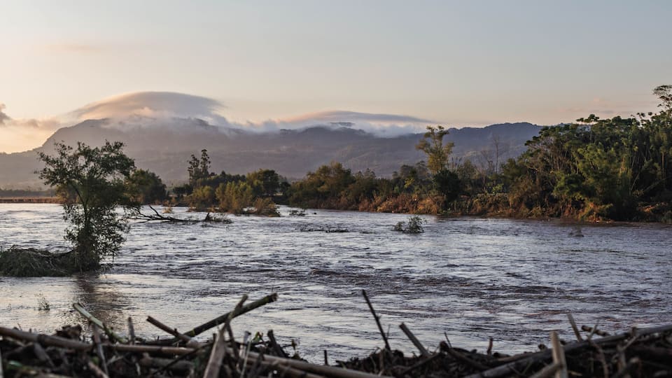 A river with trees and mountains in the background.
