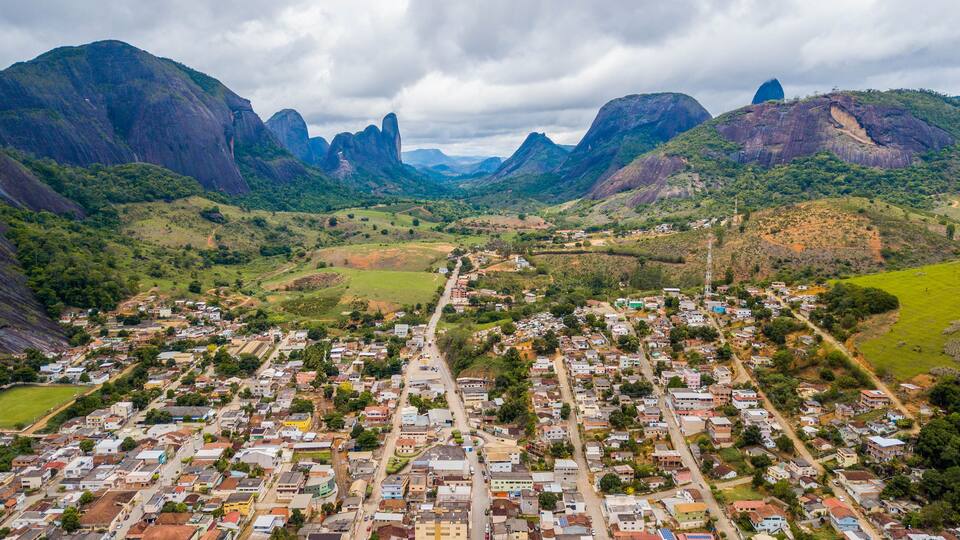A town nestled in a valley with mountains in the background.