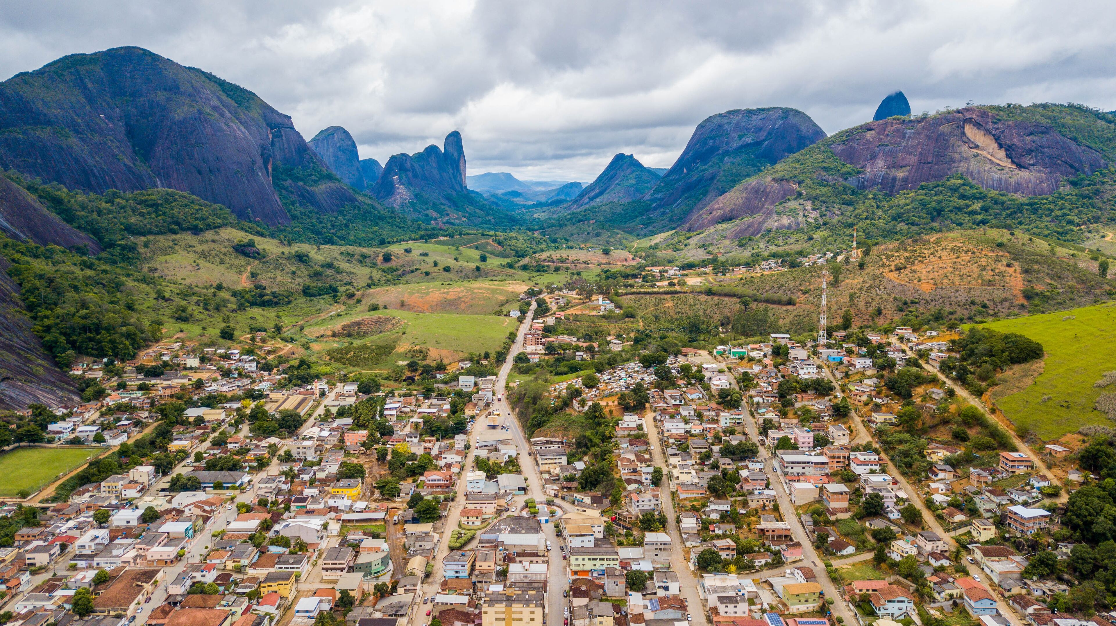 A town nestled in a valley with mountains in the background.