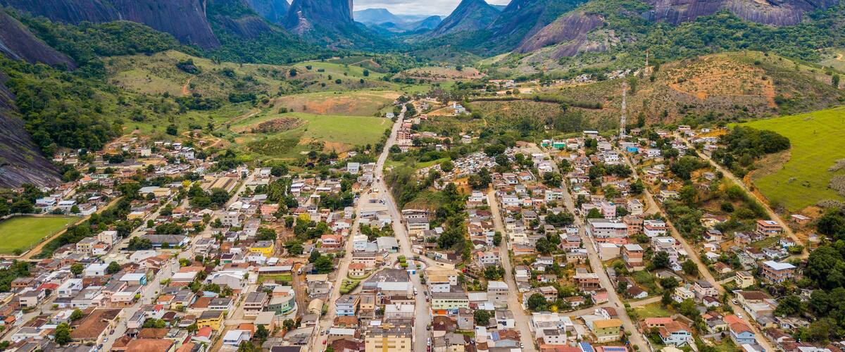 A town nestled in a valley with mountains in the background.