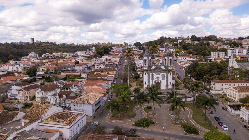 A cityscape with a prominent white church, winding roads, and residential buildings.