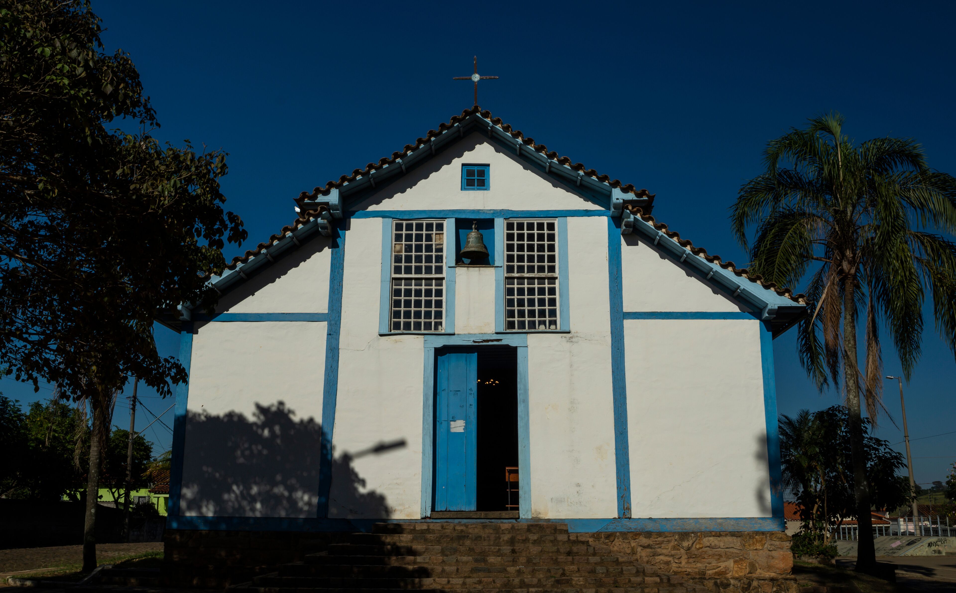 A white church with blue trim and a bell tower.