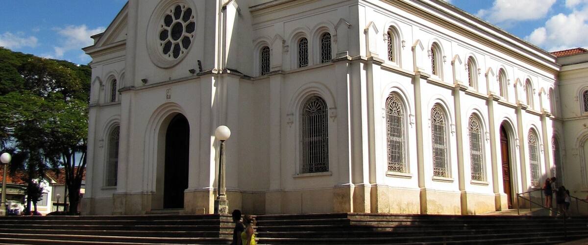 A large white church with a bell tower and a cross on top.