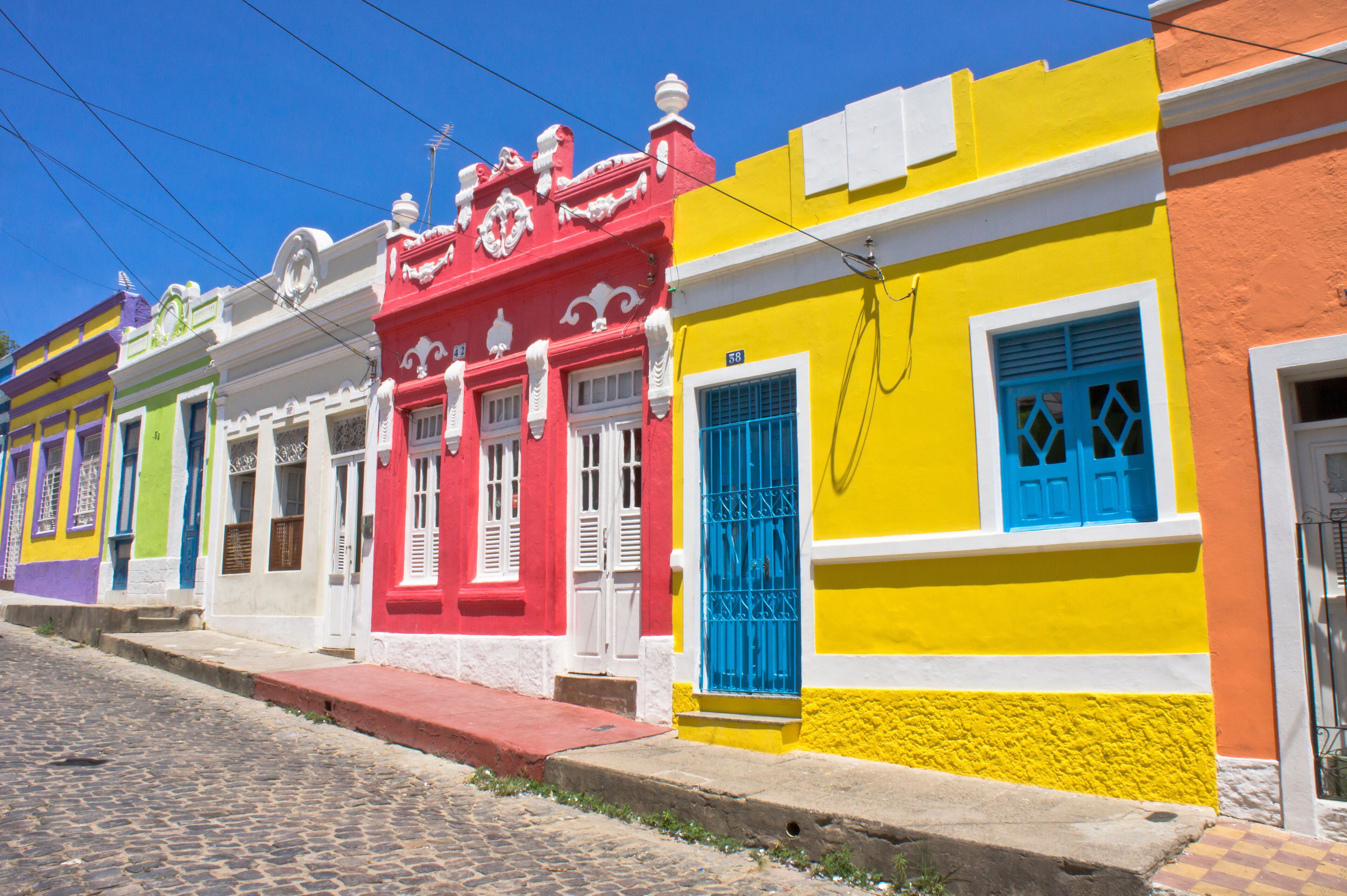 A colorful street with buildings painted in bright colors like red, yellow, and green.