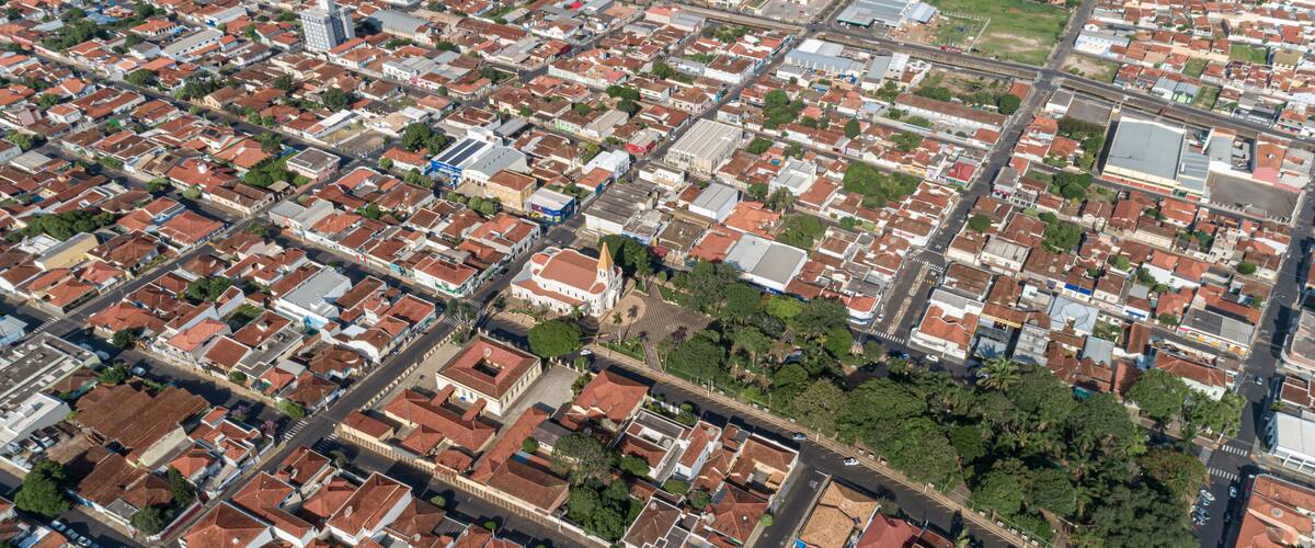 An aerial view of a densely packed urban area with numerous buildings, roads, and green spaces.