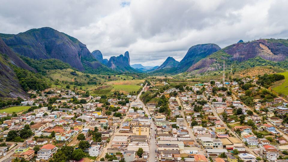 A town nestled in a valley with mountains in the background.