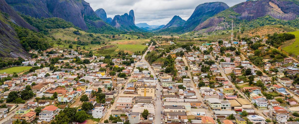 A town nestled in a valley with mountains in the background.