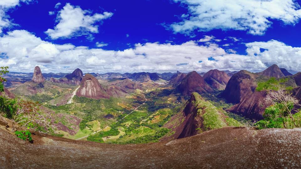 A mountainous landscape with prominent rock formations and a clear blue sky.
