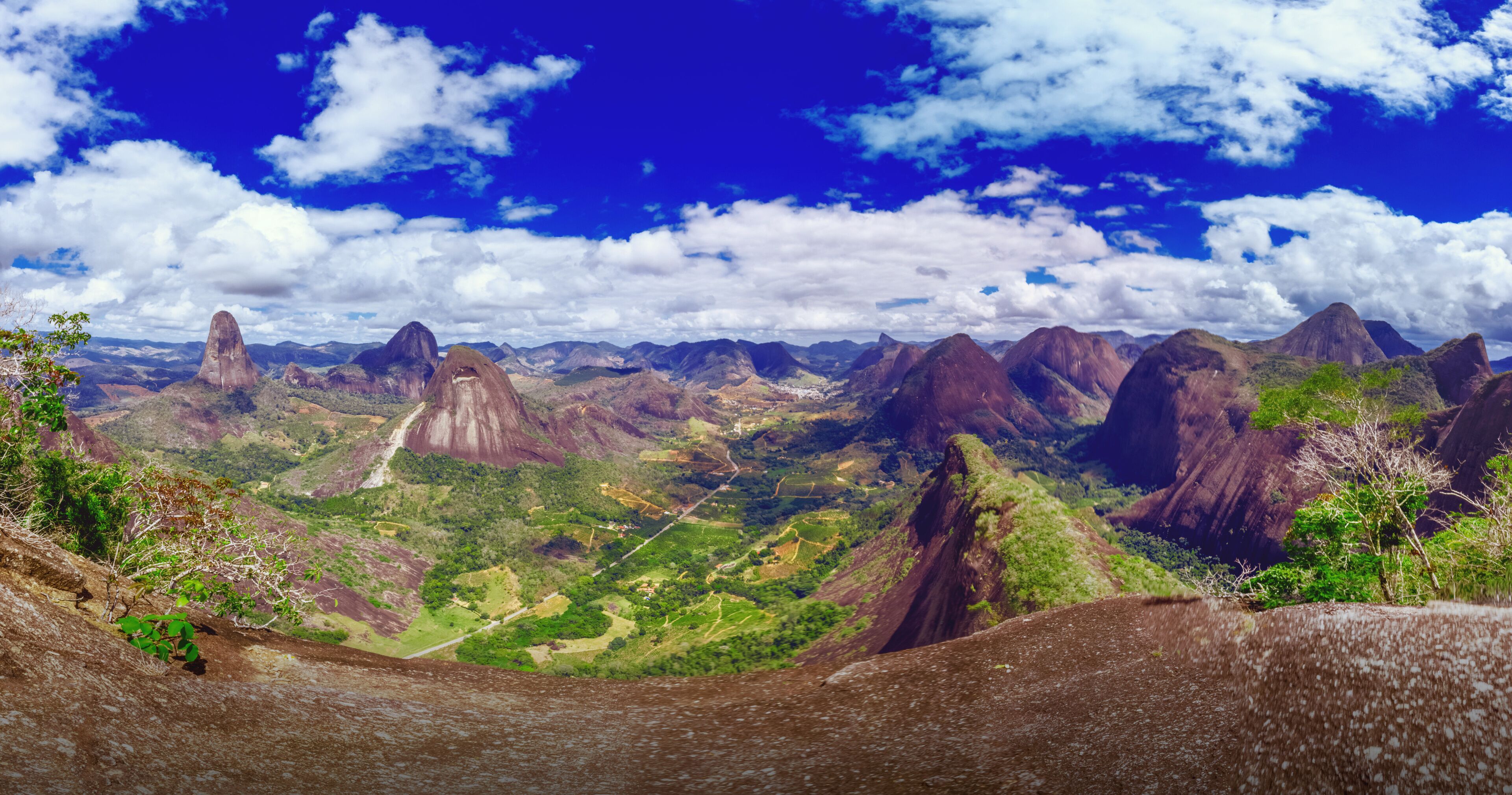 A mountainous landscape with prominent rock formations and a clear blue sky.