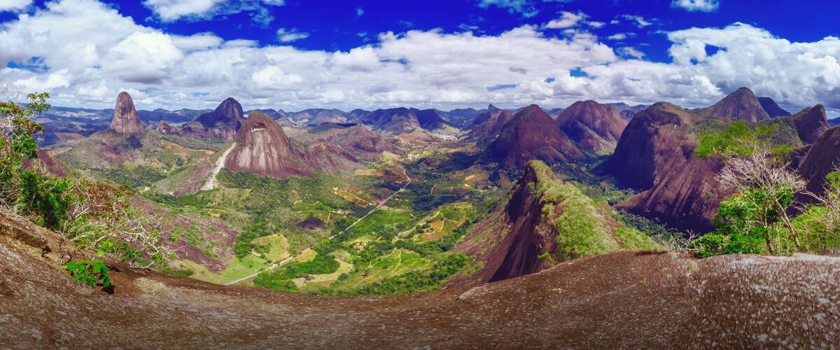 A mountainous landscape with prominent rock formations and a clear blue sky.