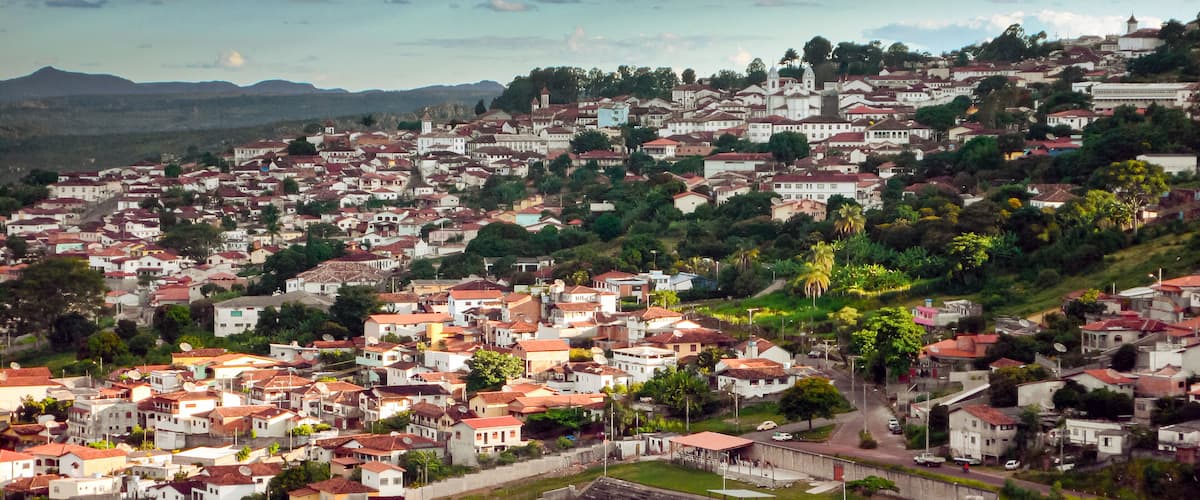 A densely populated hillside town with red-roofed houses and a prominent church.
