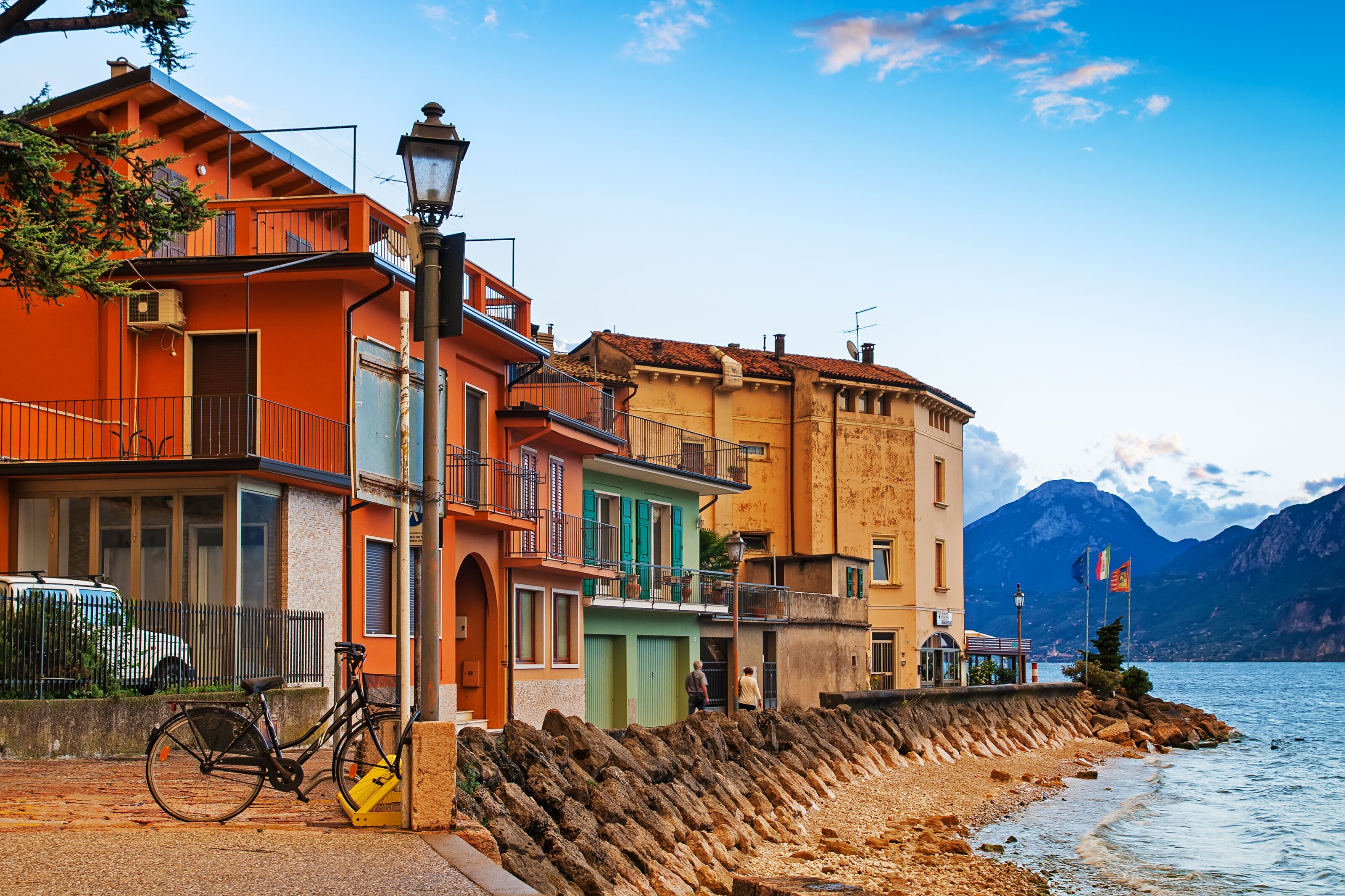 A coastal town with colorful buildings, a bicycle, and a rocky shoreline.