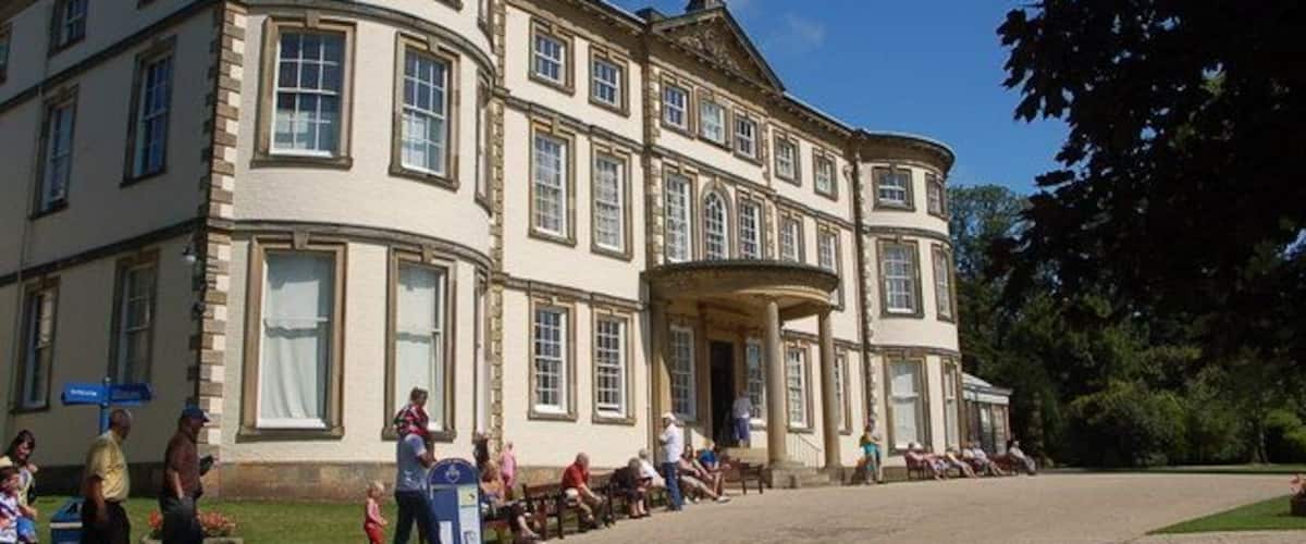 A large, historic building with a curved facade, large windows, and a central entrance.