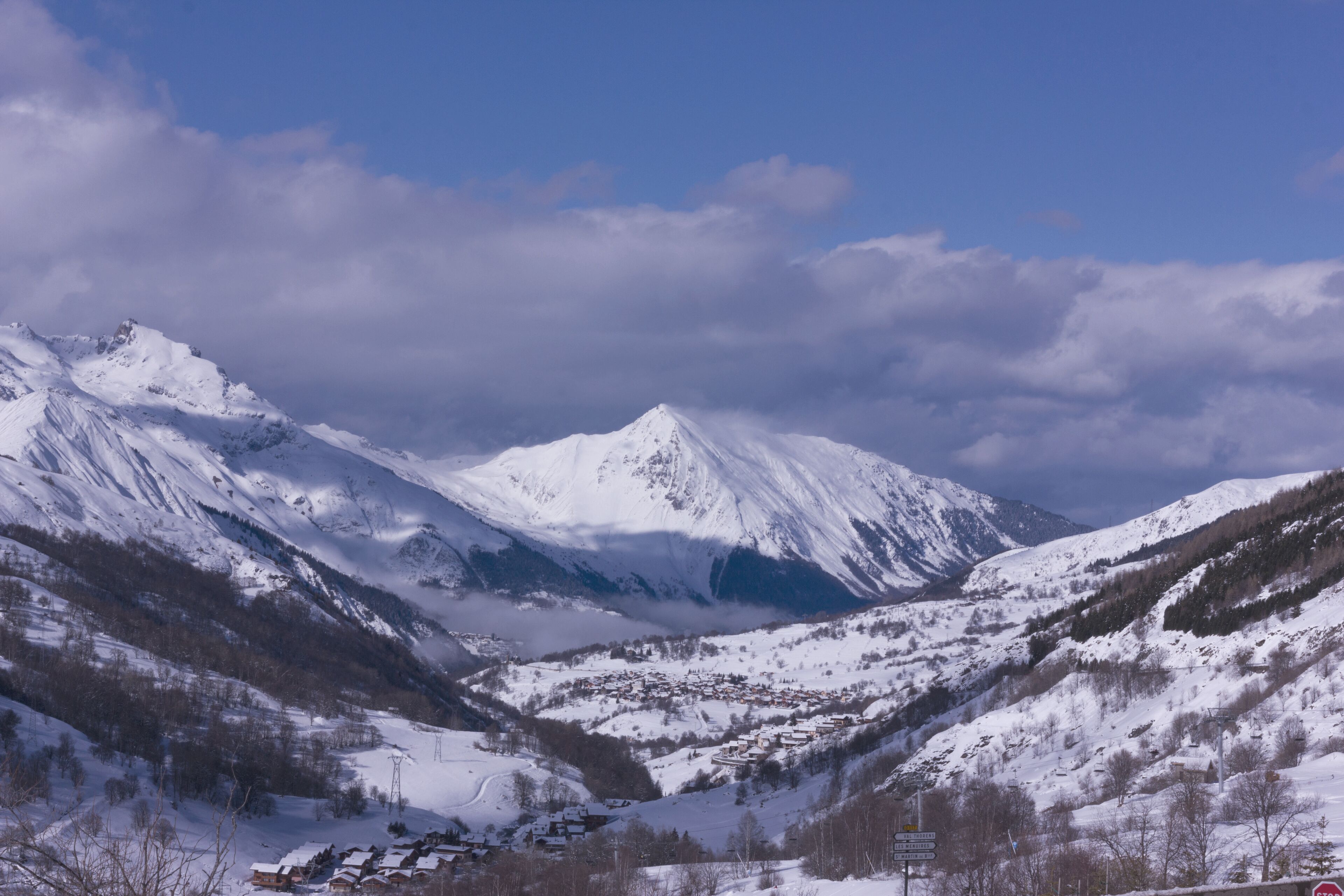 A snow-covered mountain range with a village nestled in a valley.