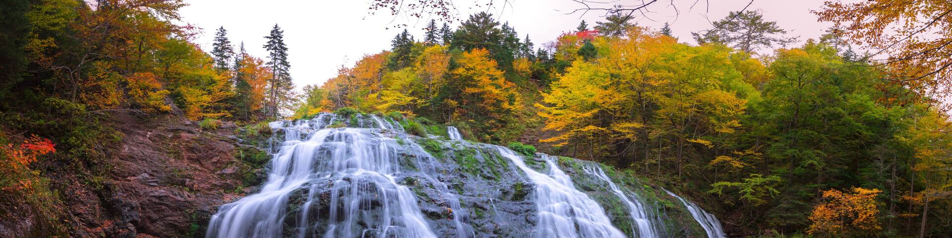 Beautiful scenery of cascading waterfalls with stunning autumn fall foliage colors. Egypt Falls, Cape Breton, Nova Scotia, Canada