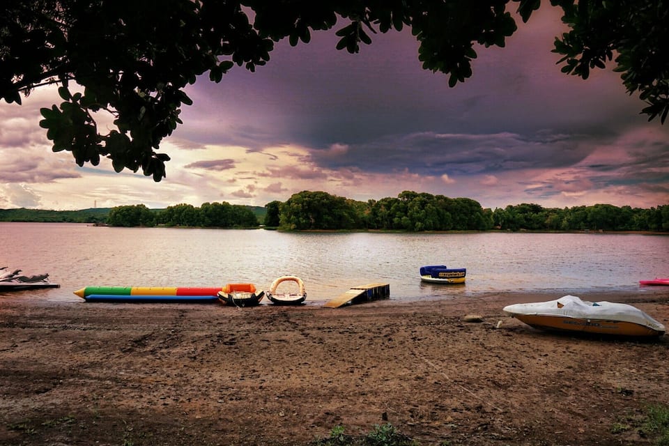 A lakeside with boats and a wooden dock.