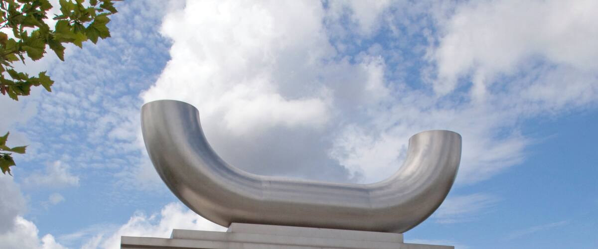 The Caryatid Gateway features two carved stone caryatids, one male and one female, each representing different aspects of Wednesbury history. The female figure represents Ethelfleda, daughter of King Alfred, who fortified Wednesbury against the Danes. The male figure represents a tube maker, Wednesbury being famous for the manufacture of tubes, the process having been patented in the nineteenth century by Cornelius Whitehouse. The tube reference is continued in the polished stainless steel inverted tubular arch 'carried' by the caryatids.