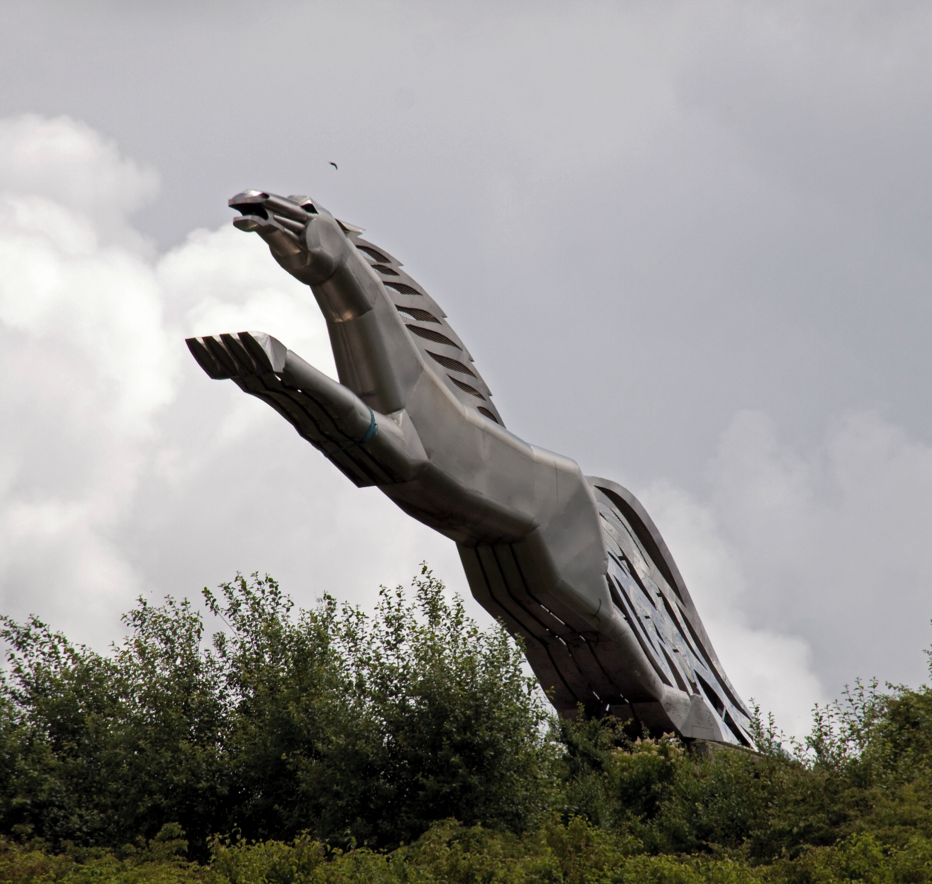 A large metallic sculpture of a hand reaching upwards.
