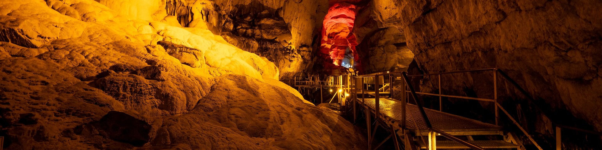 Una cueva con estalactitas y una escalera de metal.