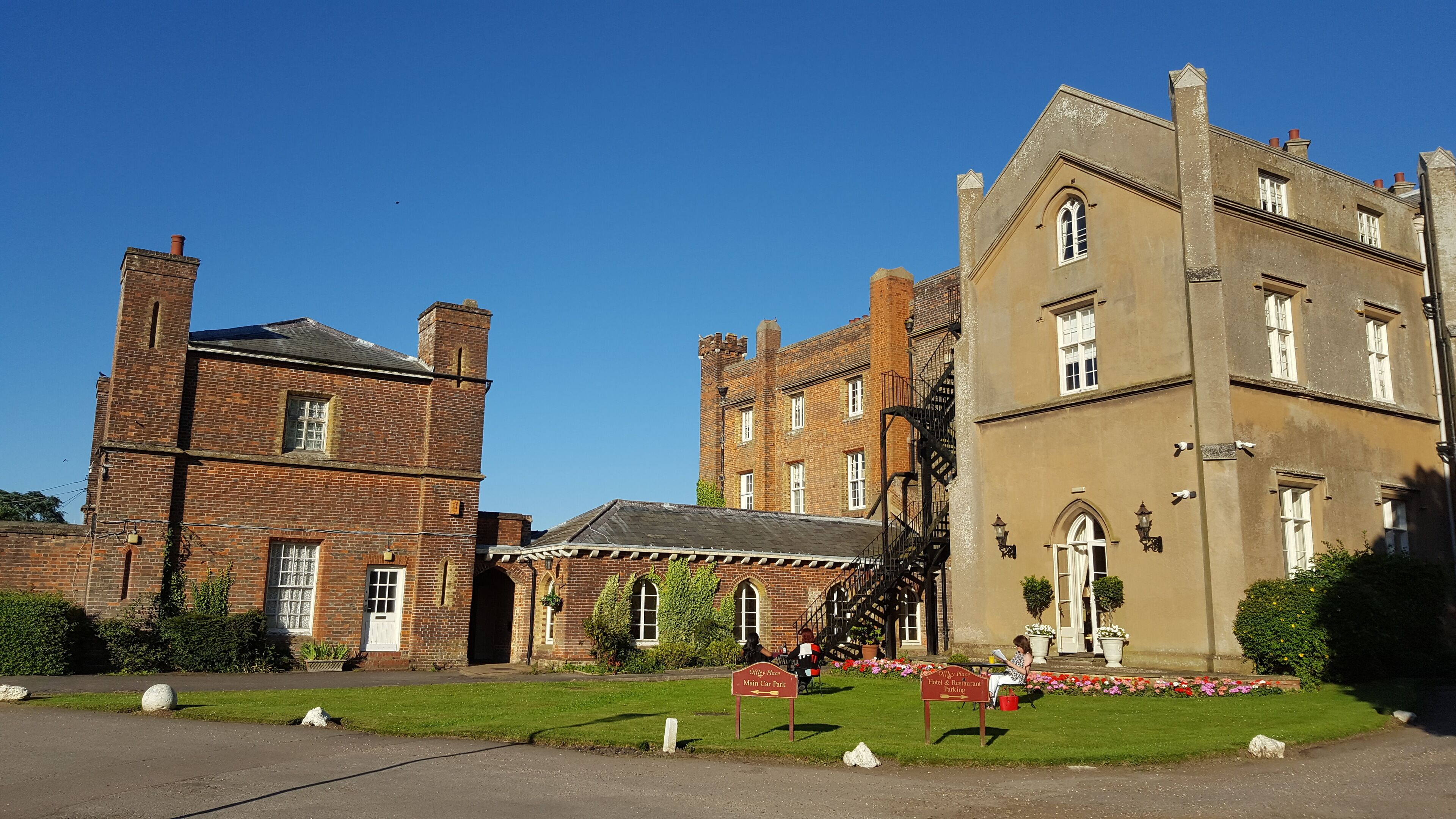 A historic building with a brick tower and a large, beige facade.