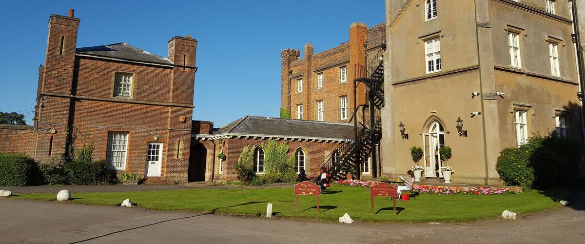 A historic building with a brick tower and a large, beige facade.