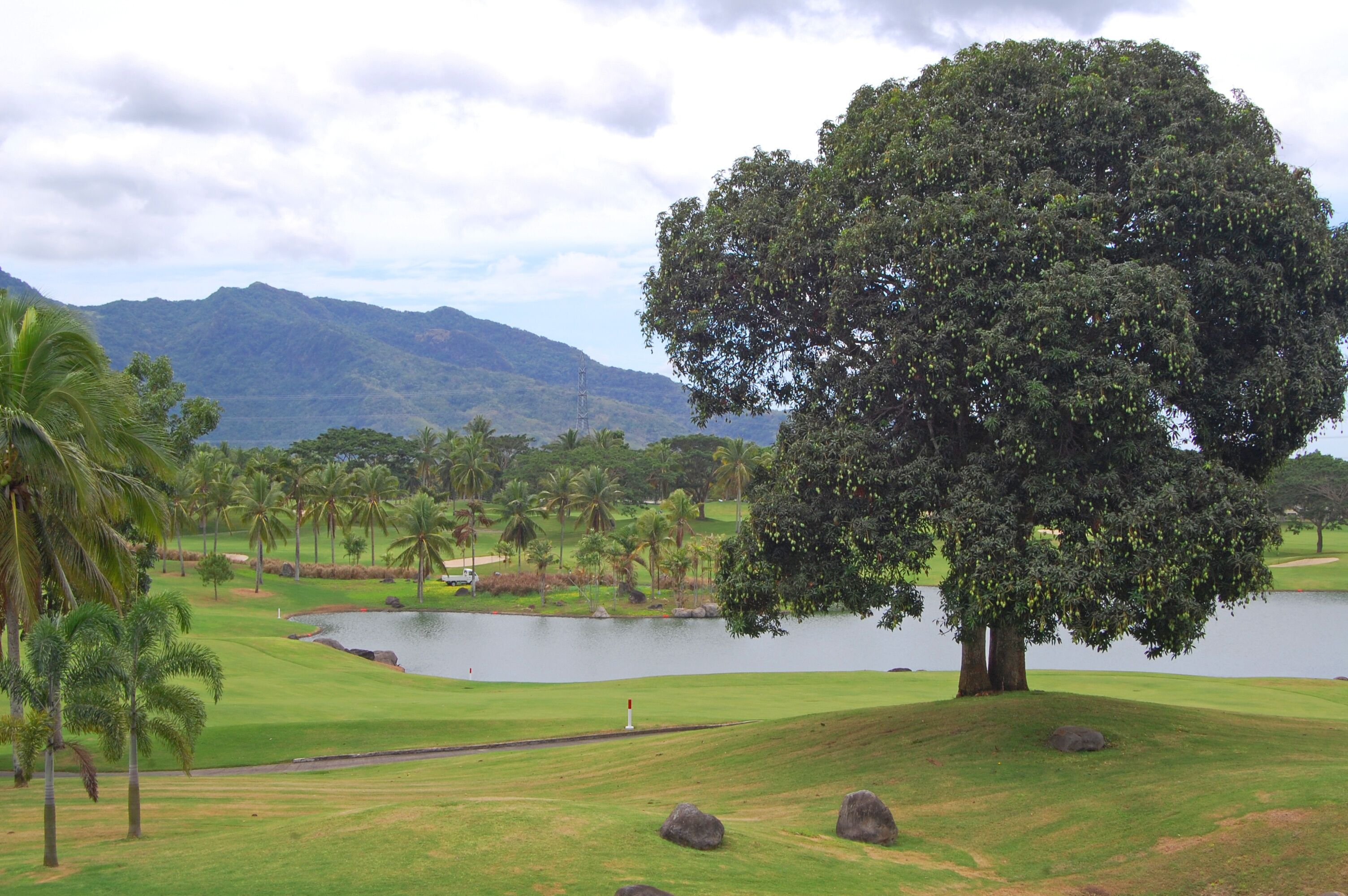 Golf course with trees, mountain, and lake at Mount Malarayat in Lipa, Batangas, Philippines