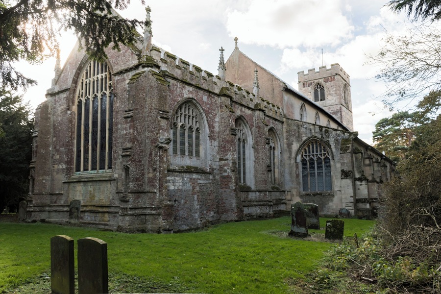 The present church is medieval and has changed little since about 1450 although there are remains of a church from 1135 which was destroyed by fire at the base of the tower. 1247 was when the foundation stone of the present church was laid and several original features of this time remain, the lower middle part of the tower, a winding staircase which would have provided access to the rood screen, a squint which would have originally been on an outside wall to allow the “unclean” and excommunicated to watch the consecration at the altar and several other features such as tomb stones. In the early 1300’s the church was altered with Sir Walter Friskney, a judge at the Court of the Exchequer in the reigns of Edward III and Richard II, being the benefactor. The nave was heightened by the addition of the clerestory and a third level was added to the tower. The chancel was also enlarged. The sedilia is late 14th century. The clerestory was decorated with wall paintings in 1320 and they can still be seen, although very faint (with the exception of The Last Supper, which was restored in 1978 at a cost of £1000). The north and south aisles were built in the 15th century and nave arches replaced the walls. The upper part of the tower now had a belfry added too plus the chancel and chapel screens were erected. The font is 15th century and originally had an ornate stone carved cover which was so heavy it had to be lifted by a pulley system.