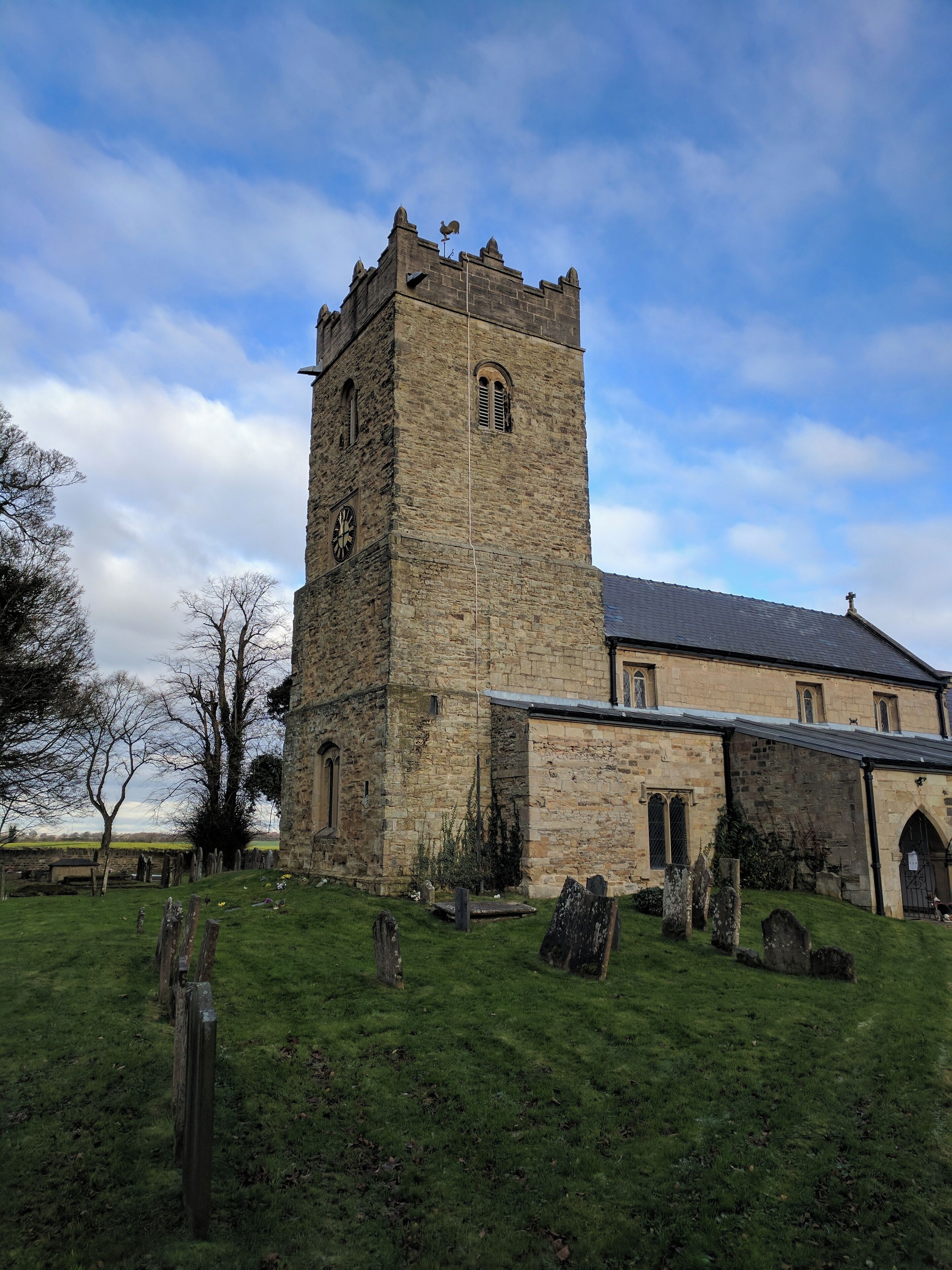 A historic stone church with a tall tower and a clock.