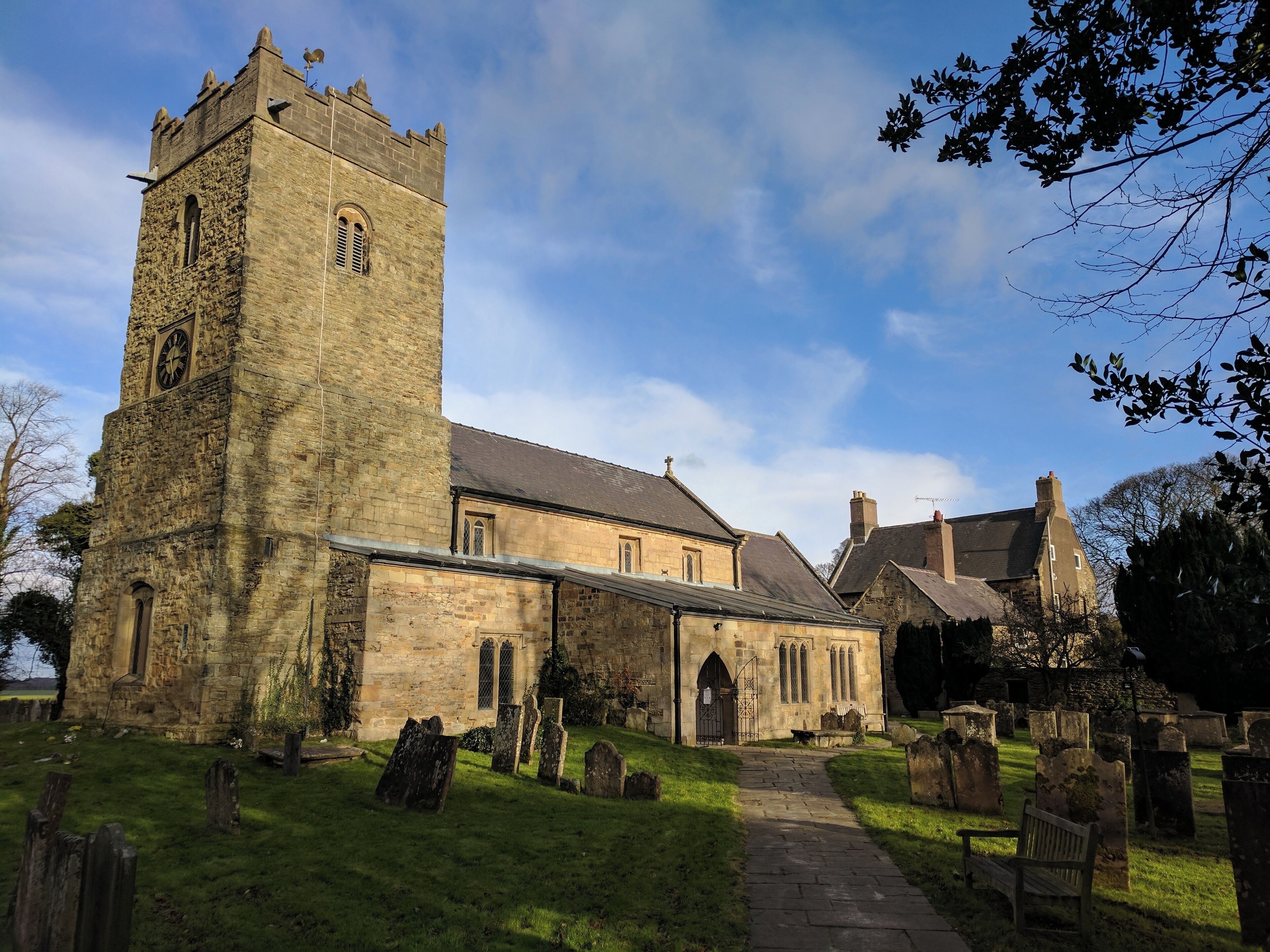 A historic church with a tall tower and a cemetery.