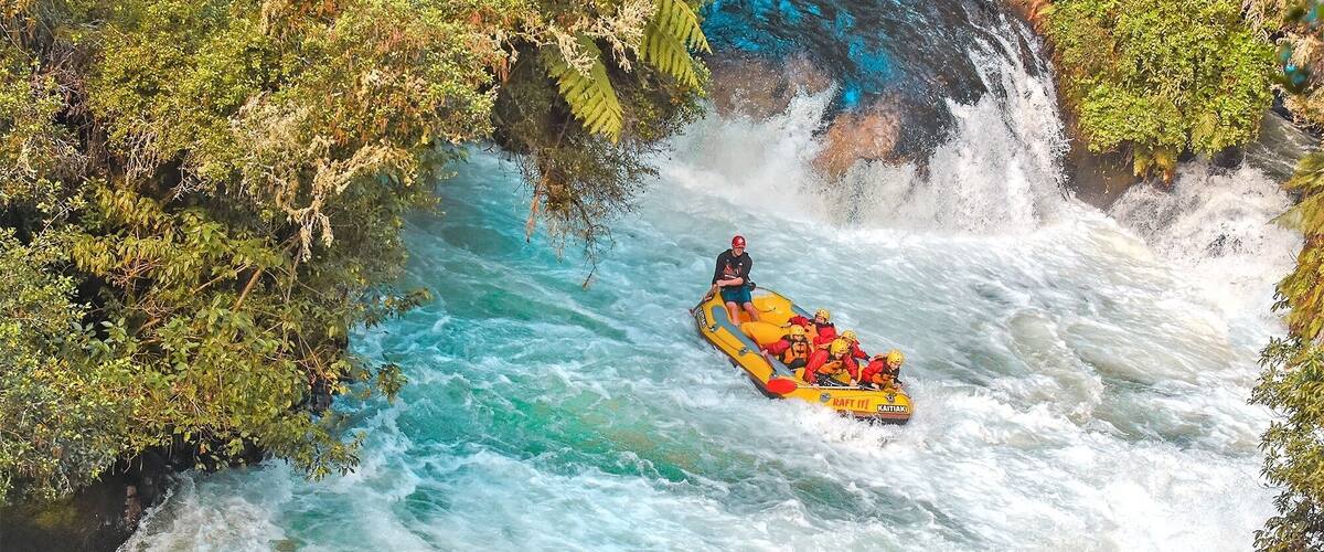 A white water rafting trip in a river surrounded by lush greenery.