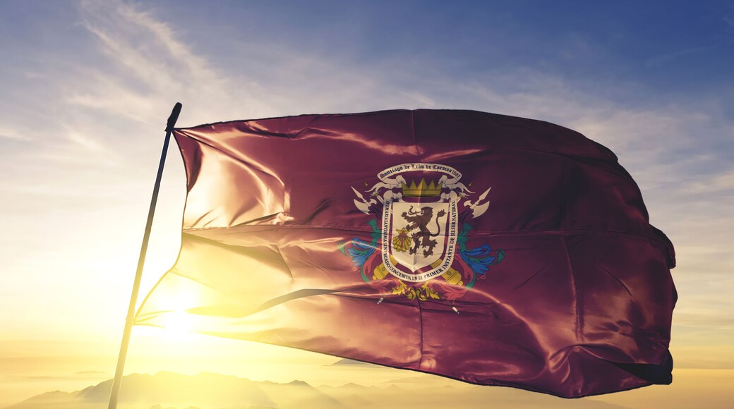 Caracas capital district of Venezuela flag waving on the top sunrise mist fog