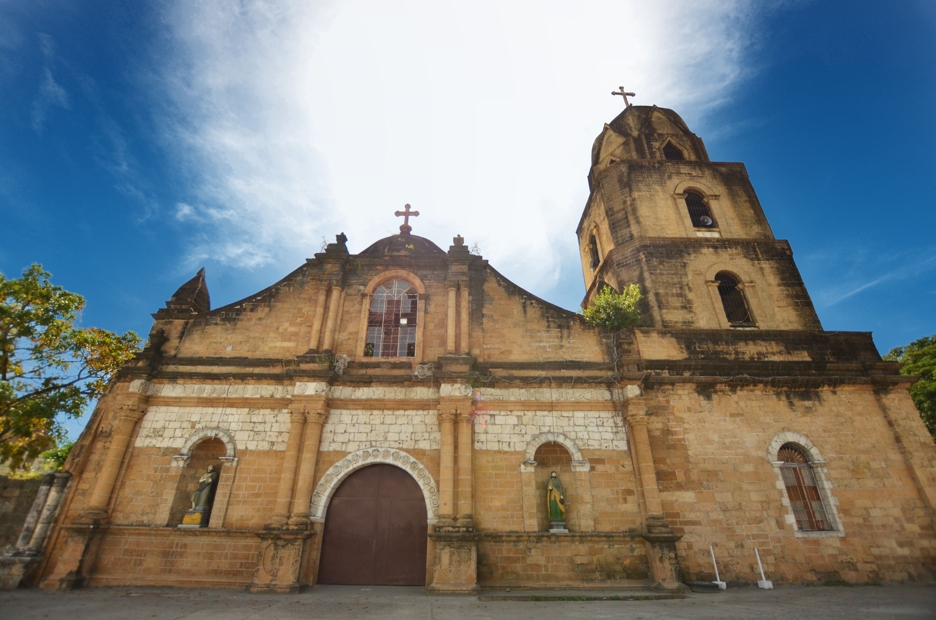 A historic church with a prominent bell tower, arched windows, and a large central doorway.