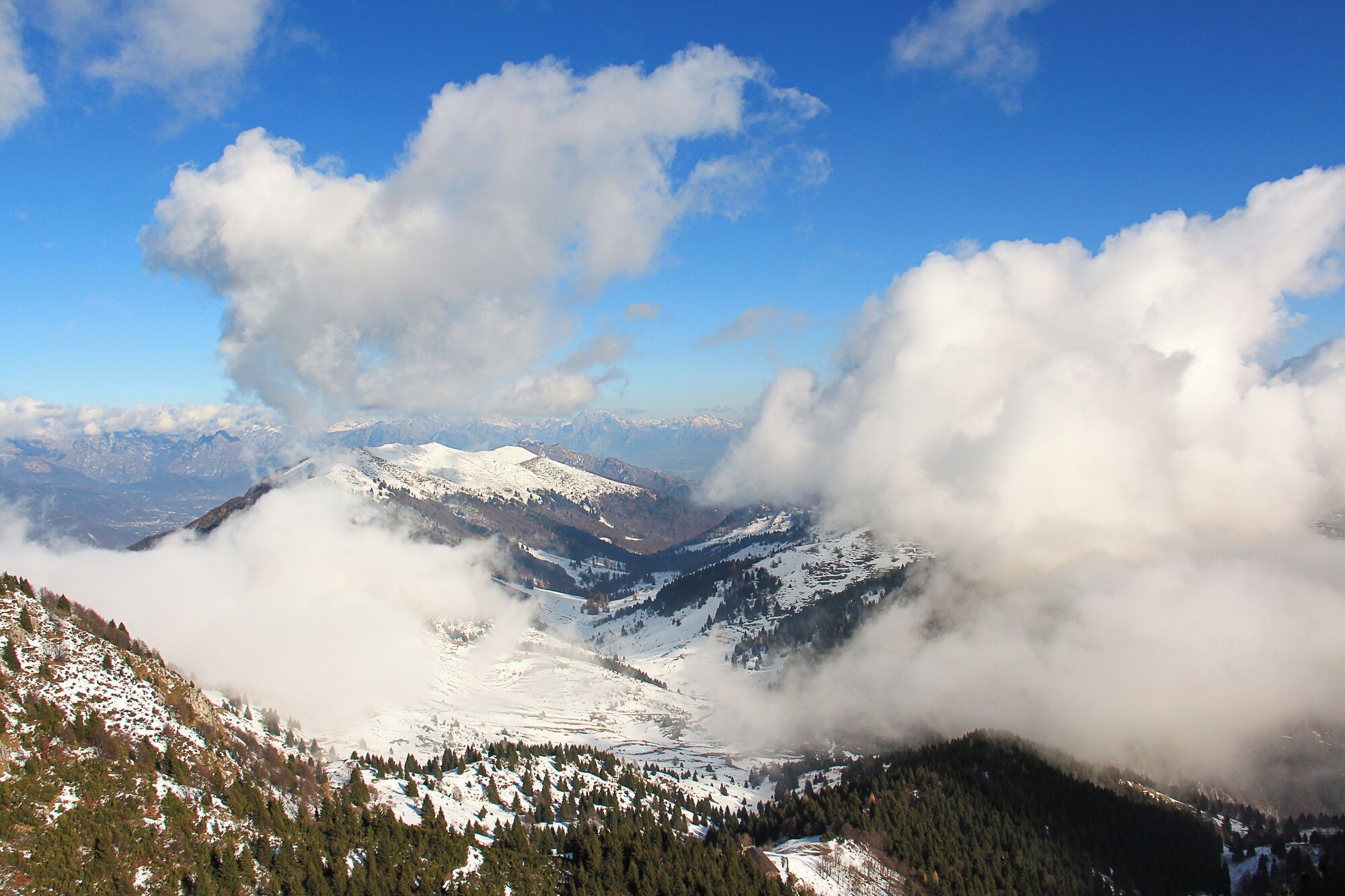 Cordilheira nevada com nuvens que cobrem parcialmente os picos.