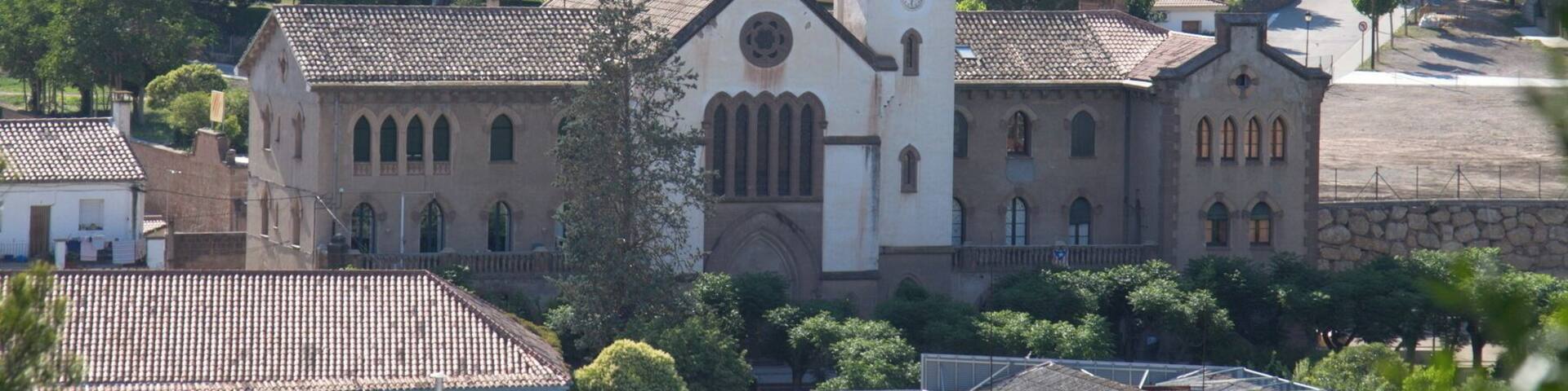 A church with a bell tower surrounded by residential buildings and trees.