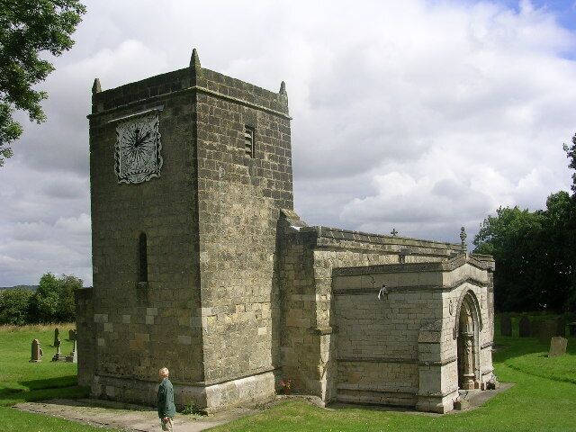 A stone church with a clock tower and an arched entrance.